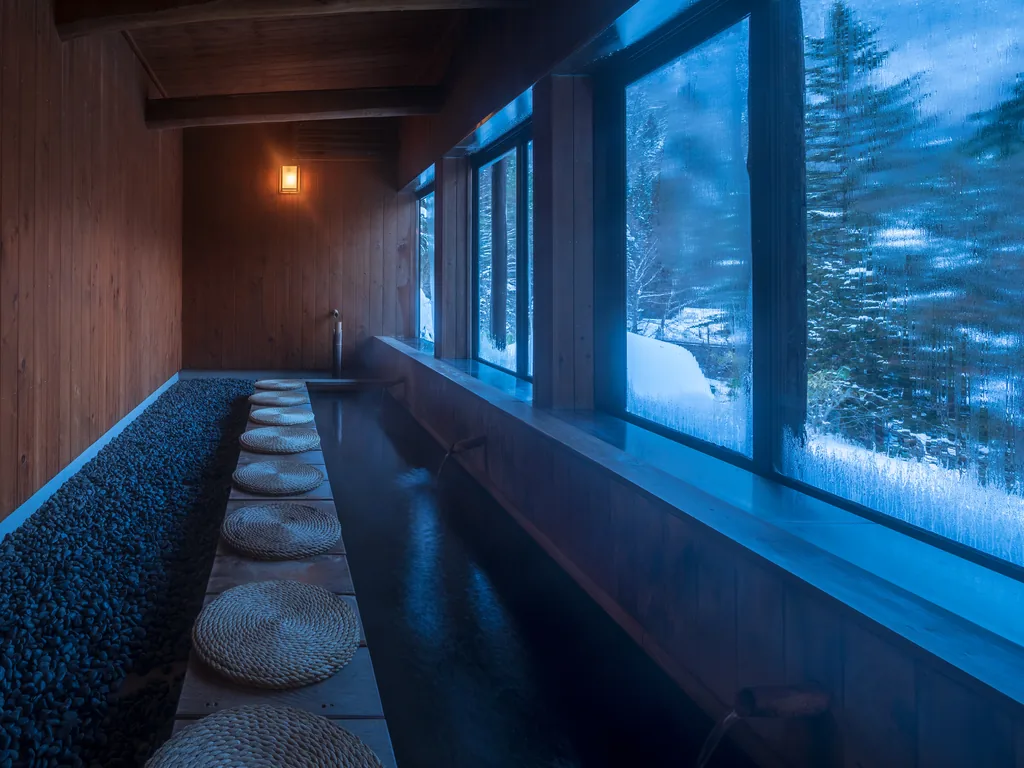 窓の外に雪景色が広がる木造の足湯